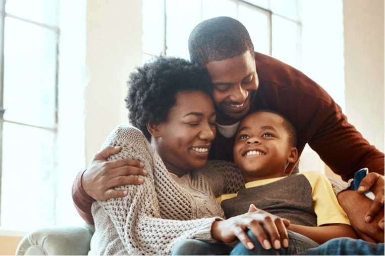 Joyful parents give an affectionate hug to their son.